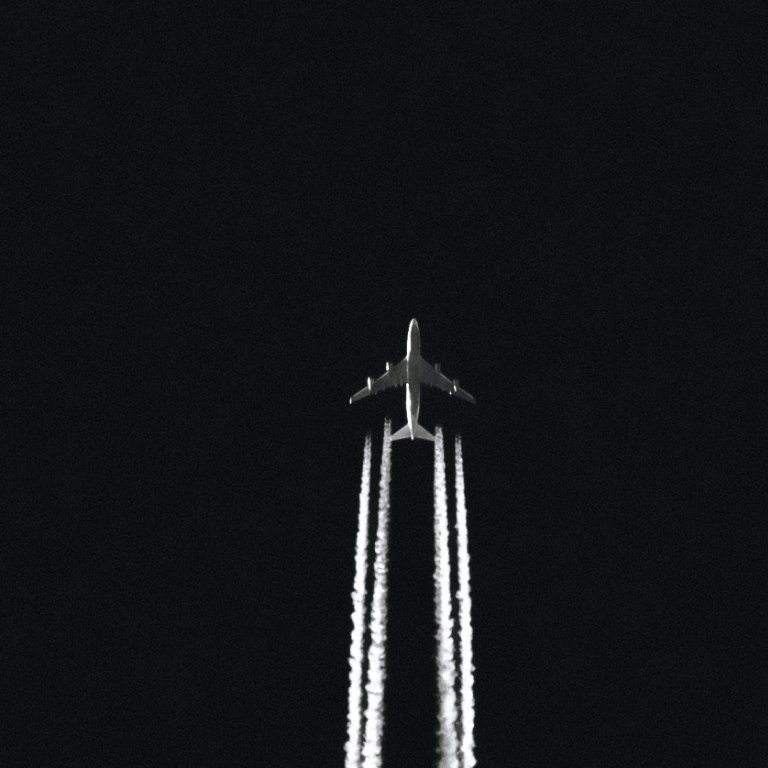 Airplane with contrails in a night sky